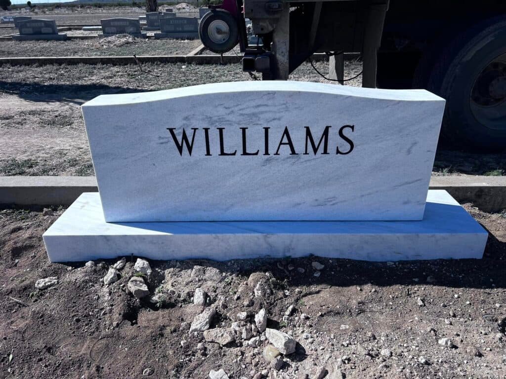 Polished black granite single upright with engraved Texas landscape across the back panel