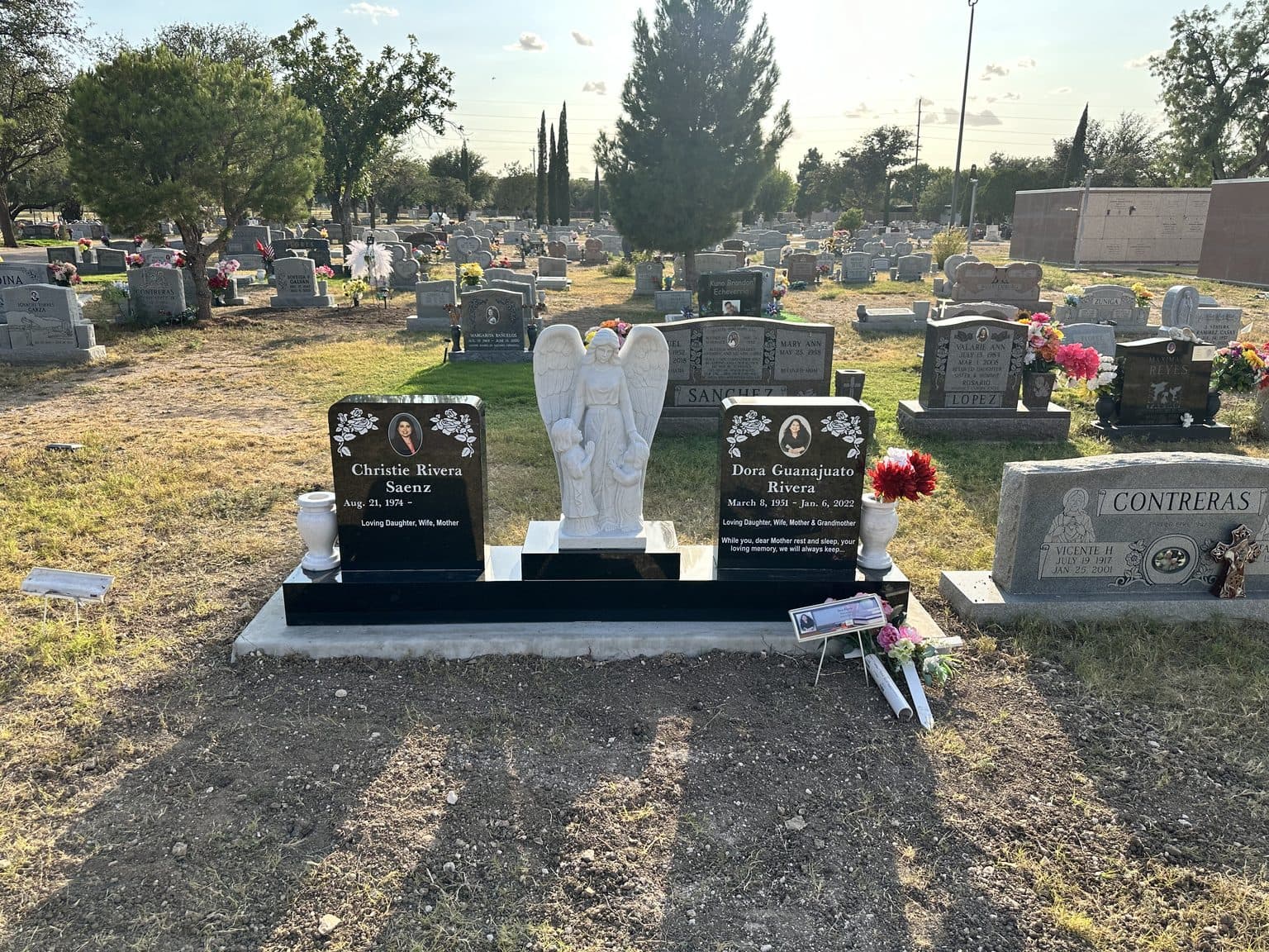 Gray granite companion upright monument with attached granite vases, set at a Texas cemetery