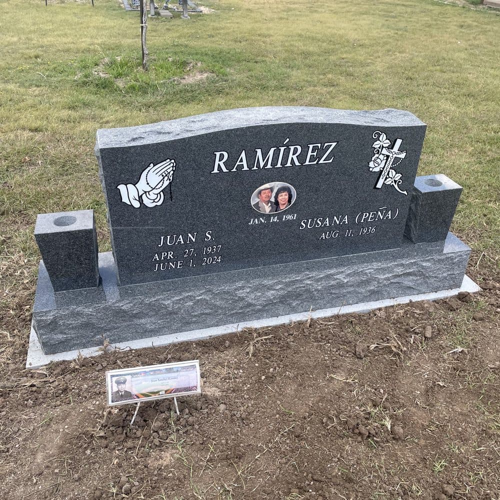 Gray granite companion upright monument with engraved emblems, set at a Texas cemetery