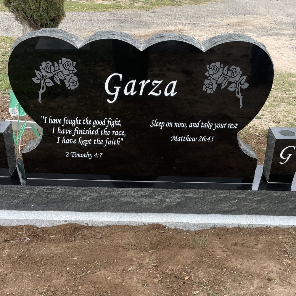 Black granite companion upright monument with twin engraved hearts, set at a Texas cemetery