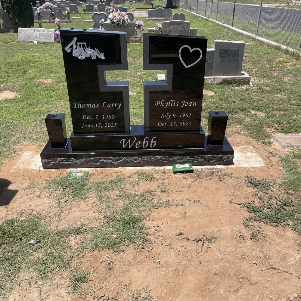 Black granite companion upright monument with an engraved cross, set at a Texas cemetery