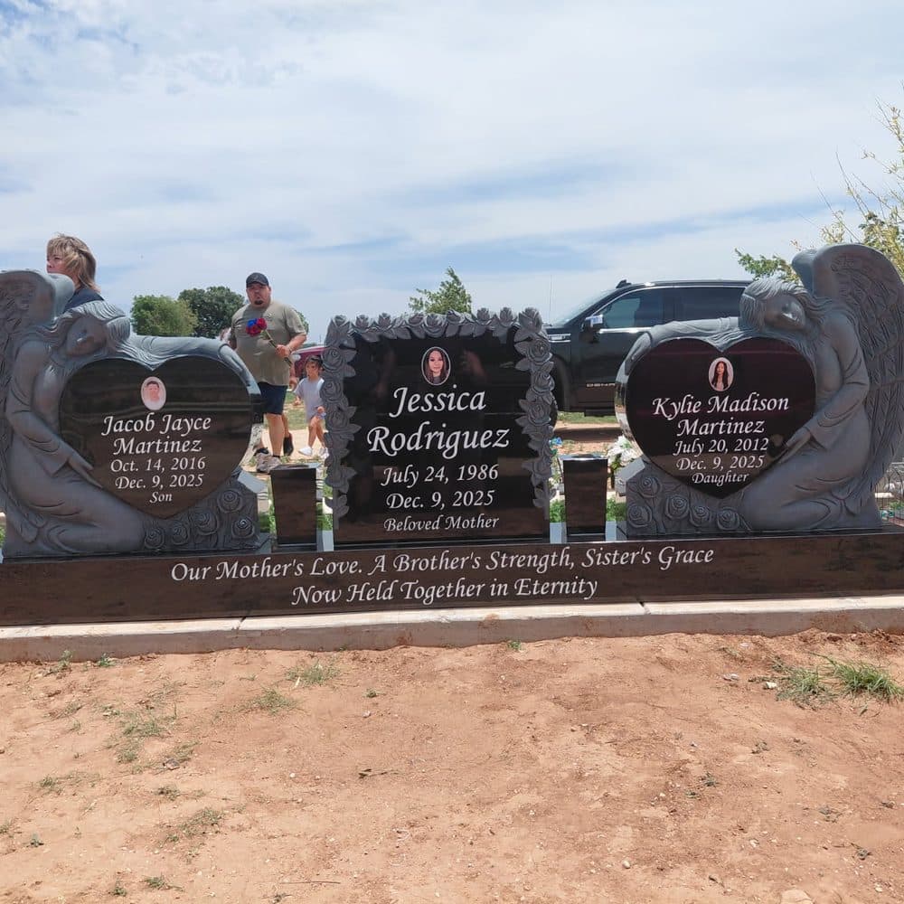 Red granite companion upright monument with twin engraved hearts, set at a Texas cemetery