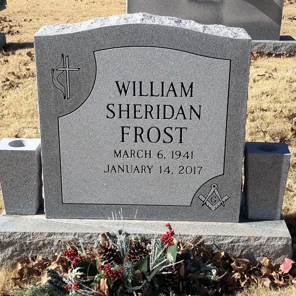 Gray granite single upright monument with a shaped polished top, set at a Texas cemetery
