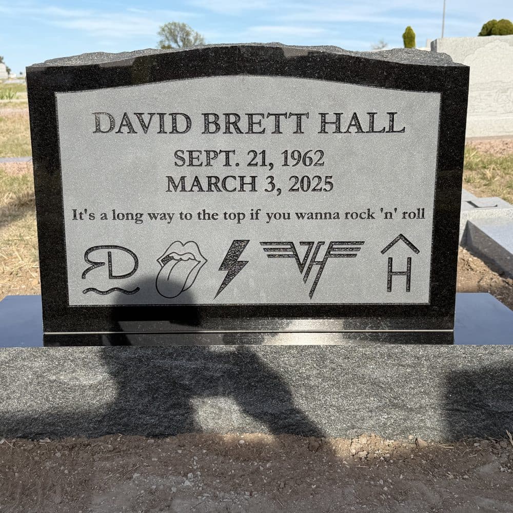 Black granite single upright monument with a polished face, set at a Texas cemetery