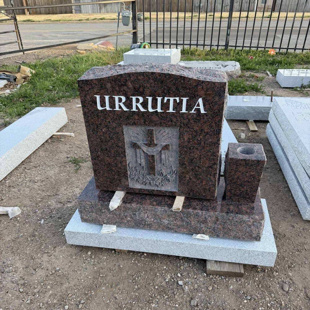Red granite single upright monument with a polished tablet, set at a Texas cemetery
