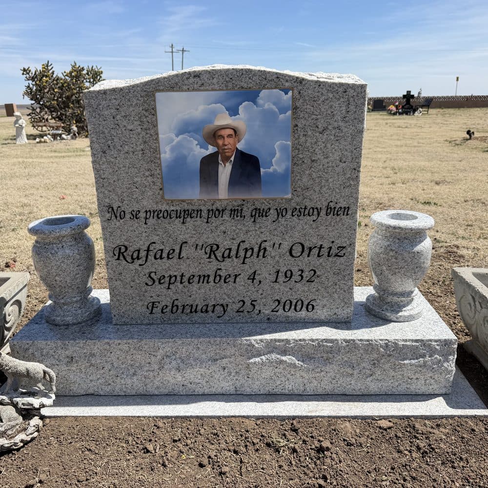 Black granite single upright monument with a porcelain photo and granite vases, set at a Texas cemetery