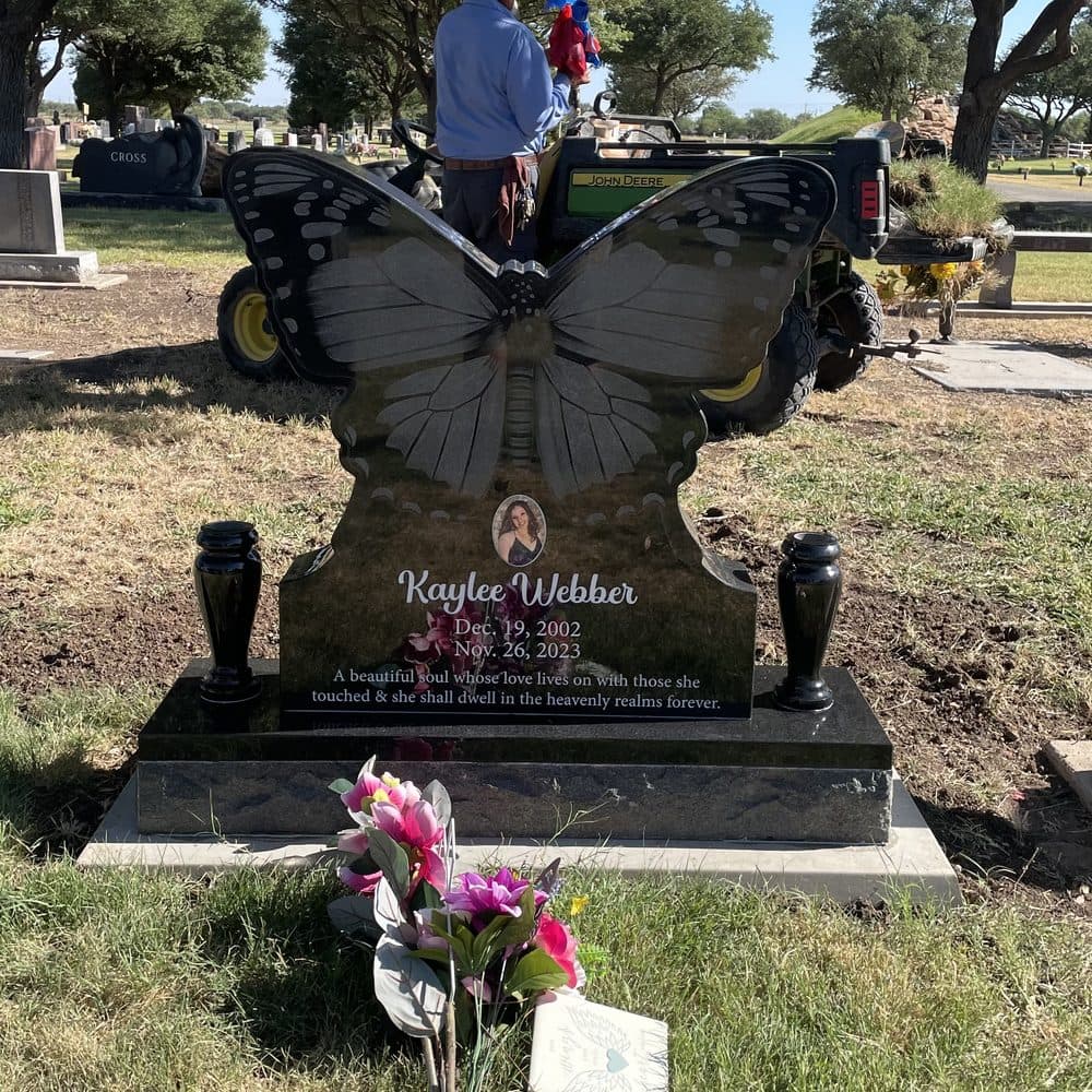 Black granite single upright monument shaped as an engraved butterfly, set at a Texas cemetery