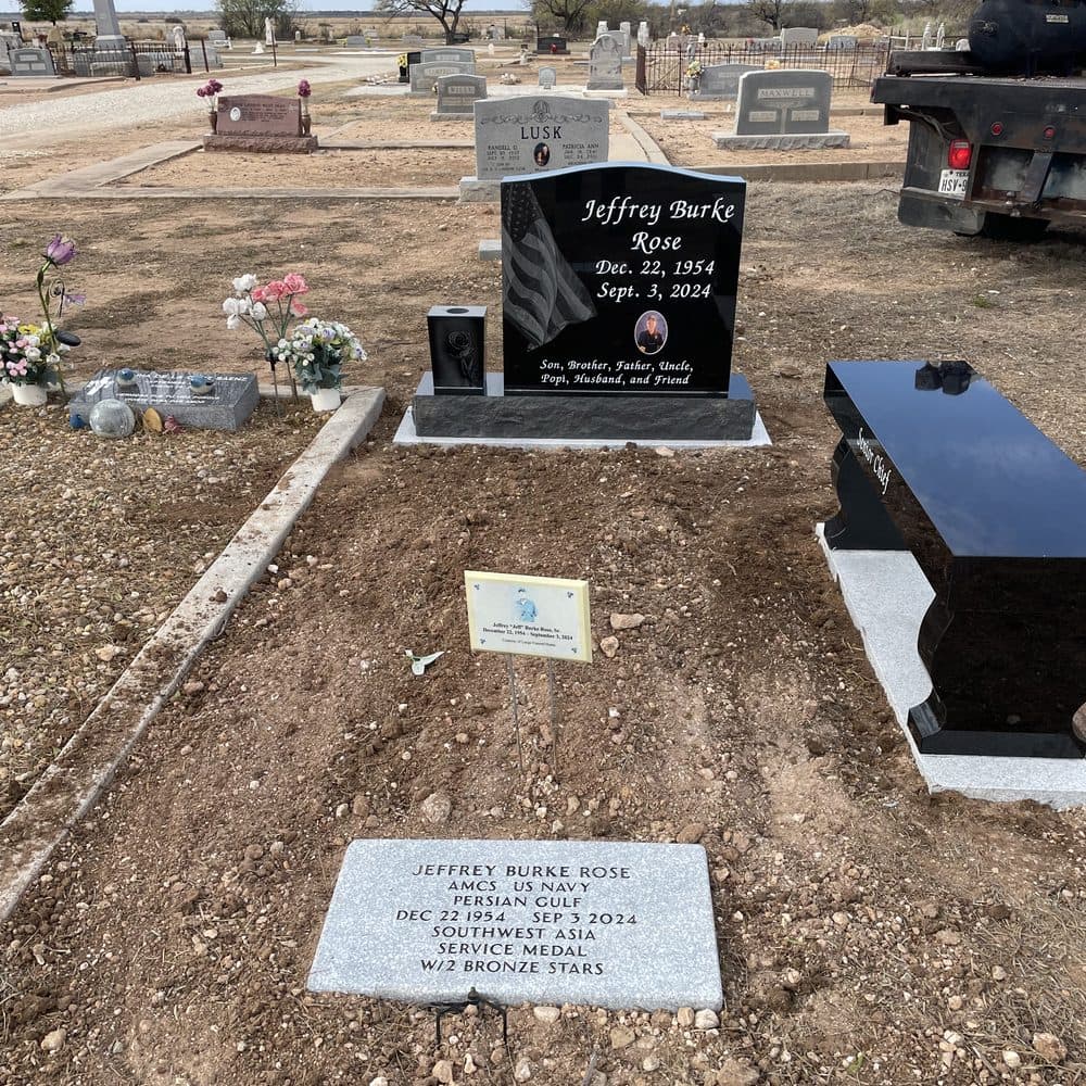Black granite single upright monument with a polished upright tablet, set at a Texas cemetery