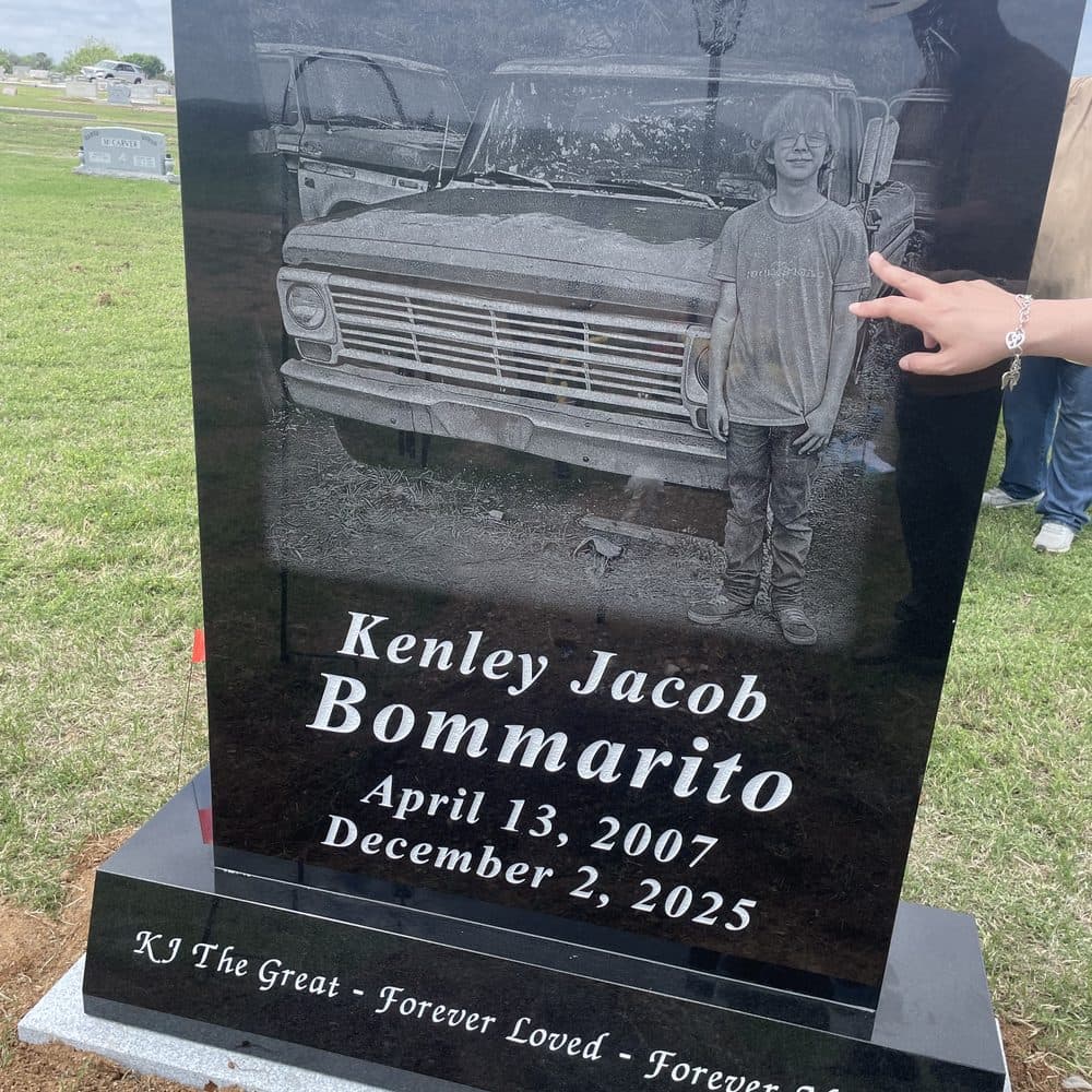 Black granite single upright monument with a laser-engraved truck and portrait, set at a Texas cemetery