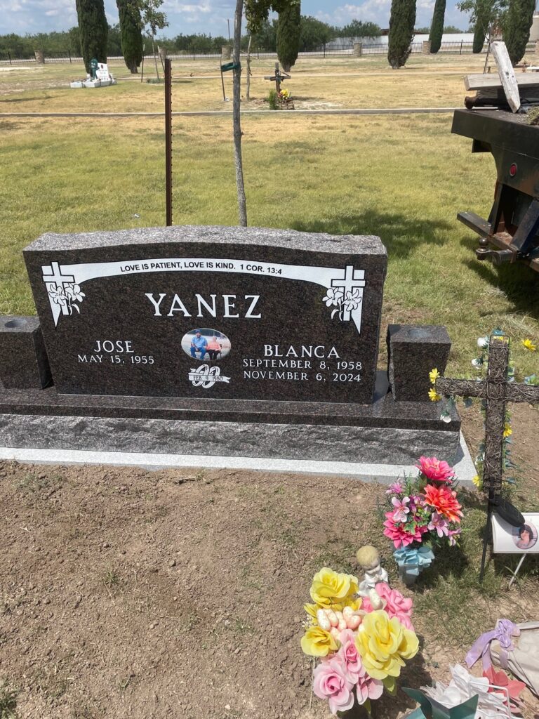Tall single upright monument with shaped panels and engraved family name, set on a poured concrete foundation